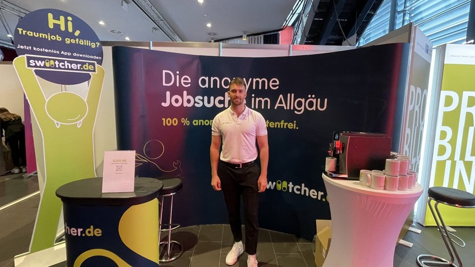 swiitcher Messestand mit Besucher*innen, Messegespräch am Stand, Touchscreen-Profilerstellung am Tablet